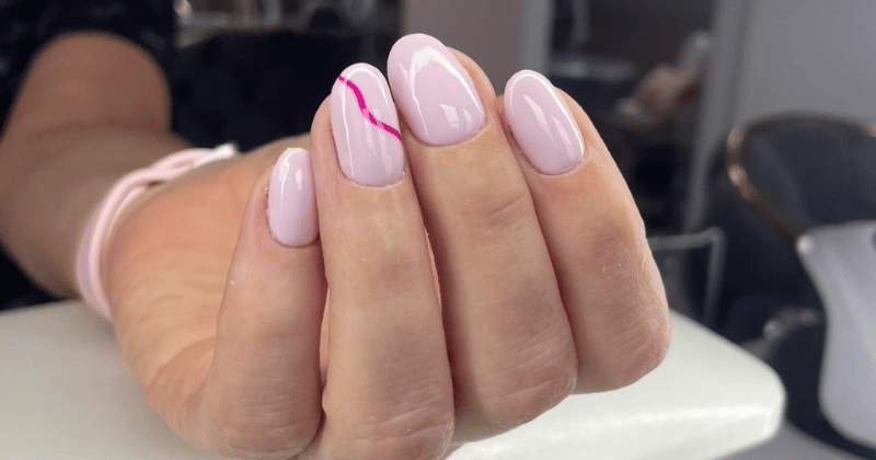 Jasnoróżowy manicure hybrydowy z subtelnym zdobieniem linią