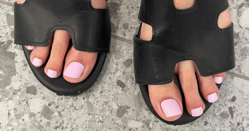 Różowy pedicure hybrydowy w czarnych sandałach – jesienny pedicure 2025 Lublin